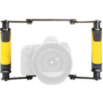 A DSLR camera mounted inside a bright yellow and black Ikan Dragonfly camera rig, featuring two side handles for handheld stabilization.
